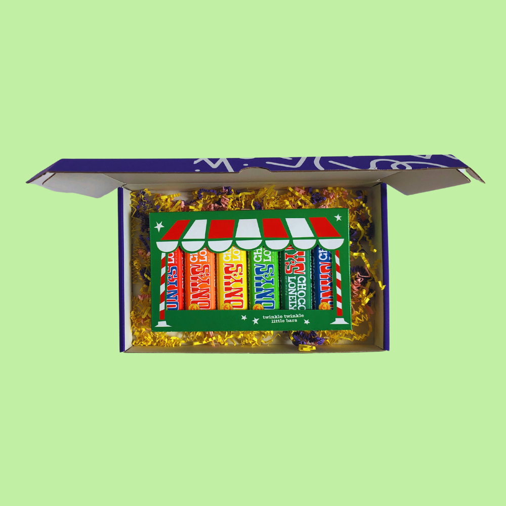 Christmas Express Box open, six Tony's Chocolonely mini bars in different flavours on wood wool