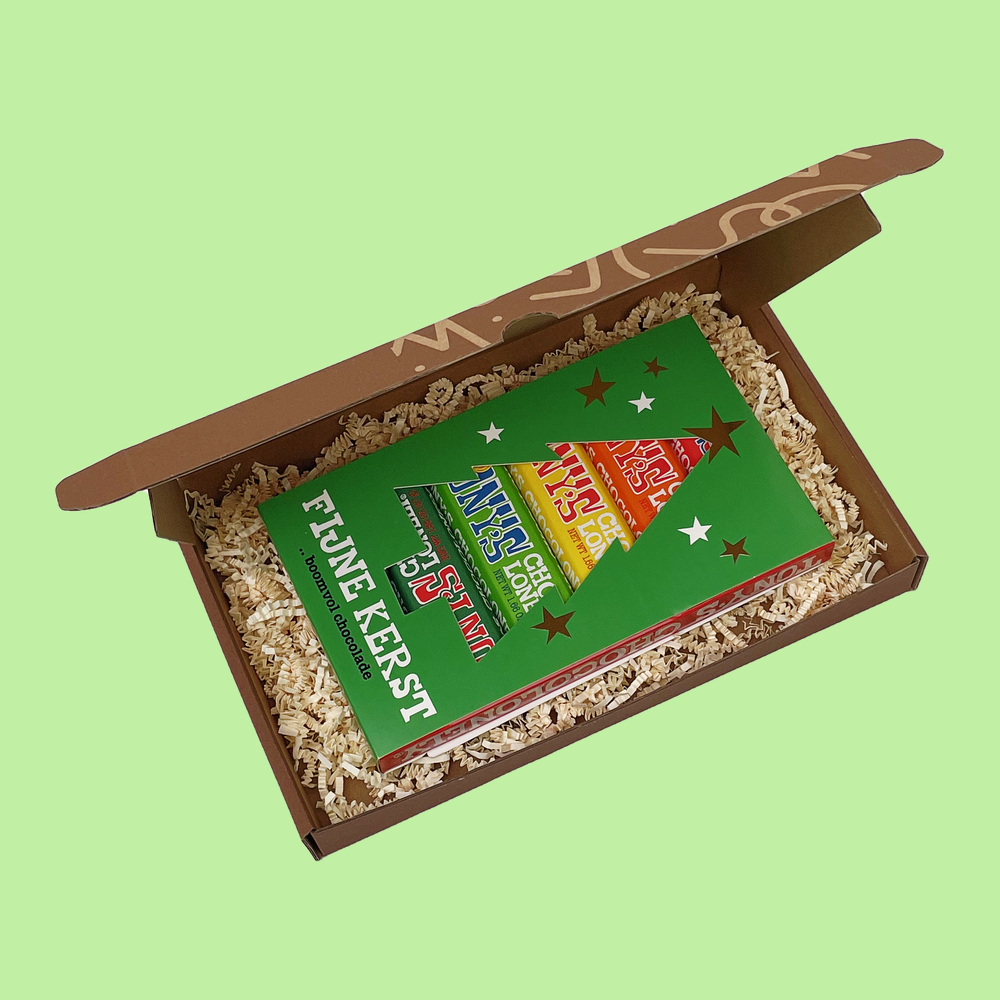 Christmas Express Box open from above, a green Fijne Kerst card over six Tony's Chocolonely mini bars on wood wool